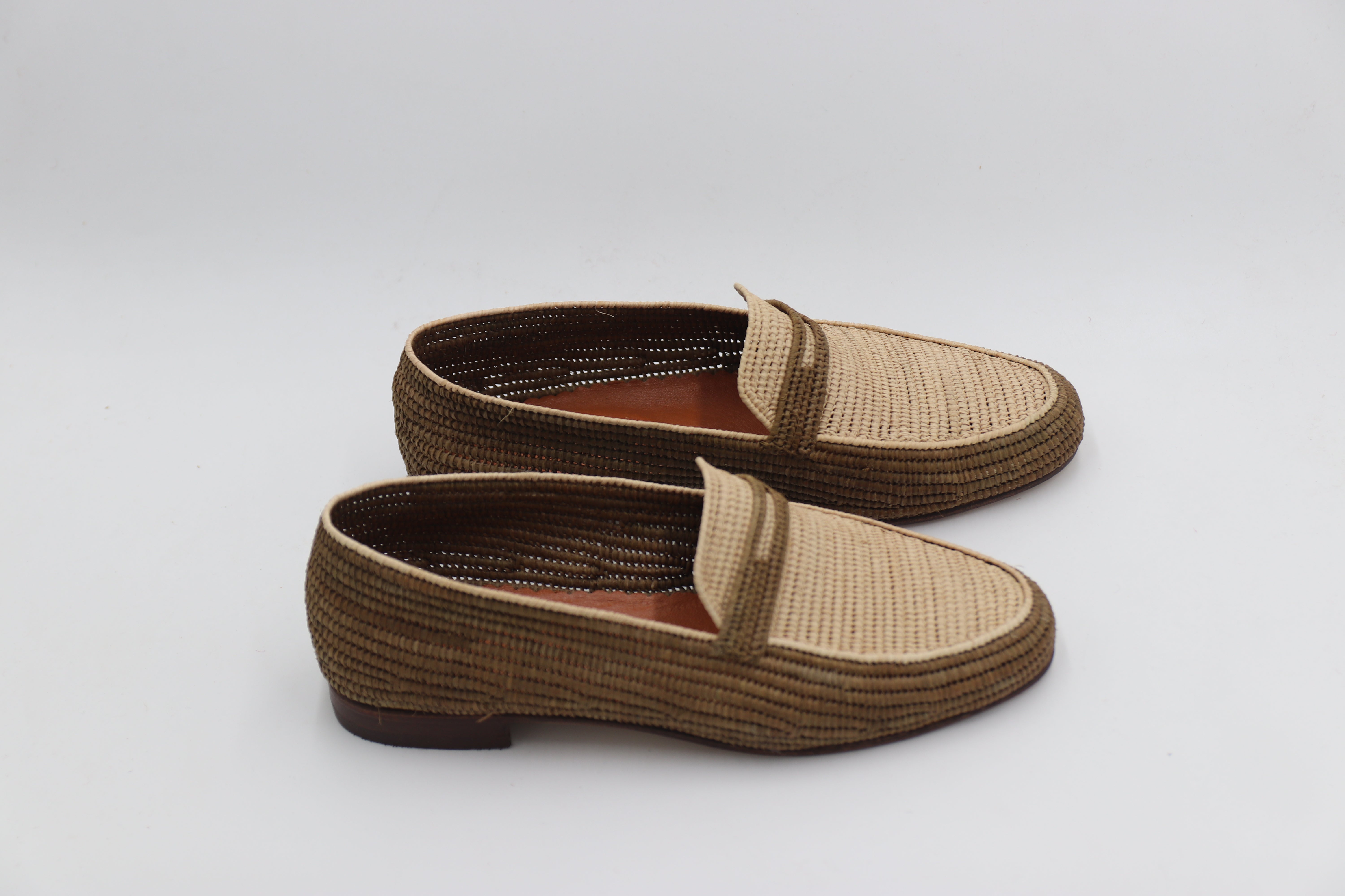 Lightweight raffia loafers for men displayed with linen trousers

