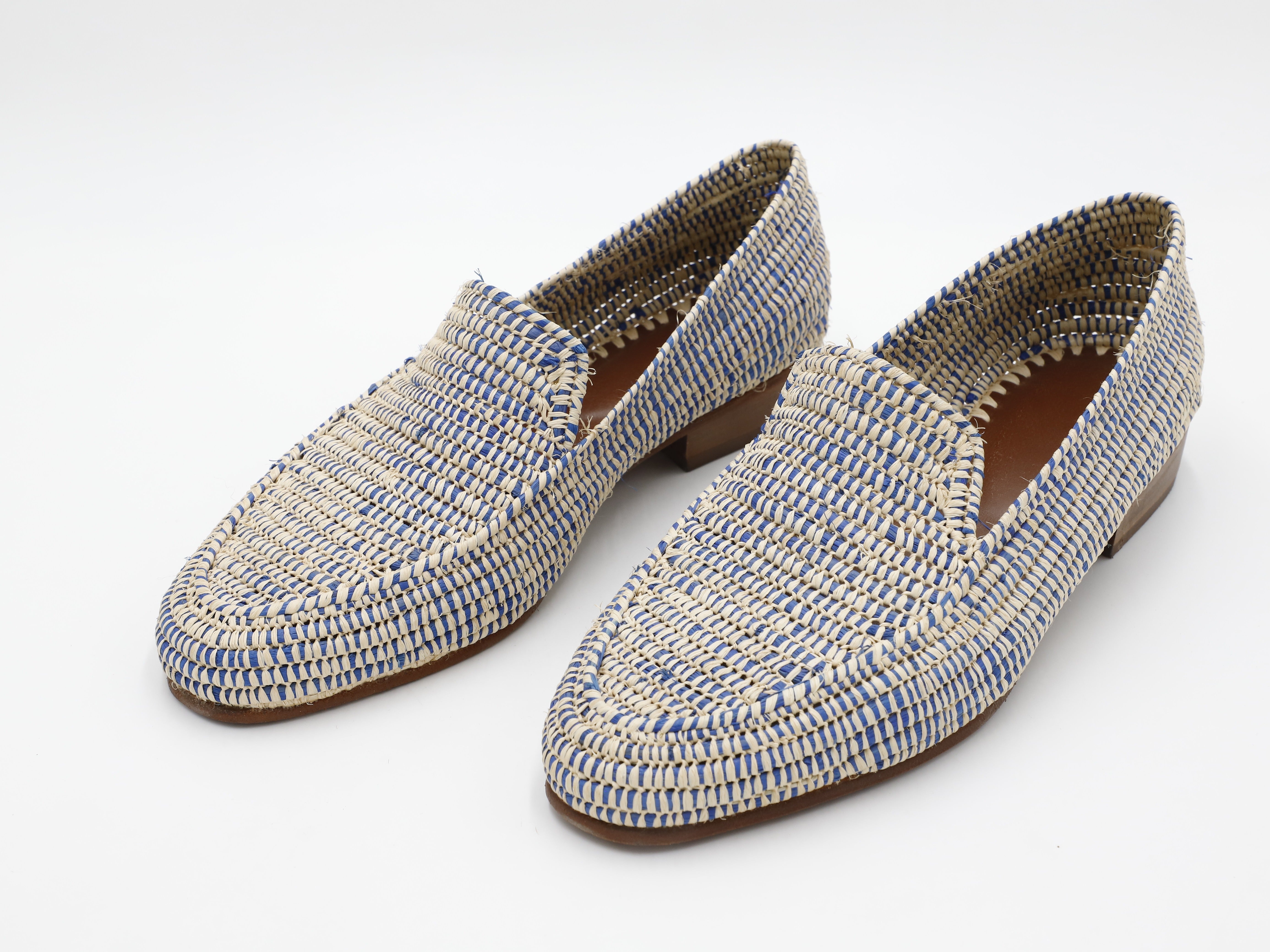 Pair of blue and beige woven loafers on a white background