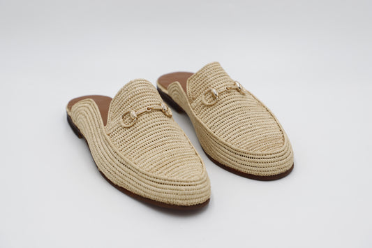 Pair of beige woven mules on a white background
