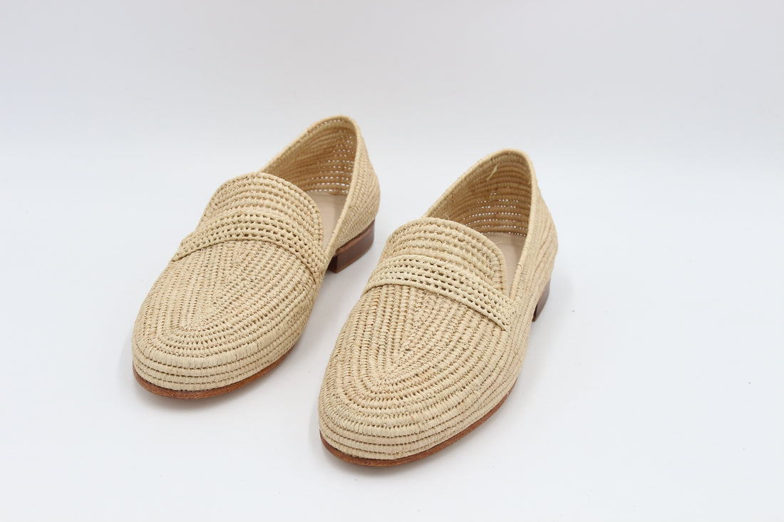 Pair of beige woven loafers on a white background