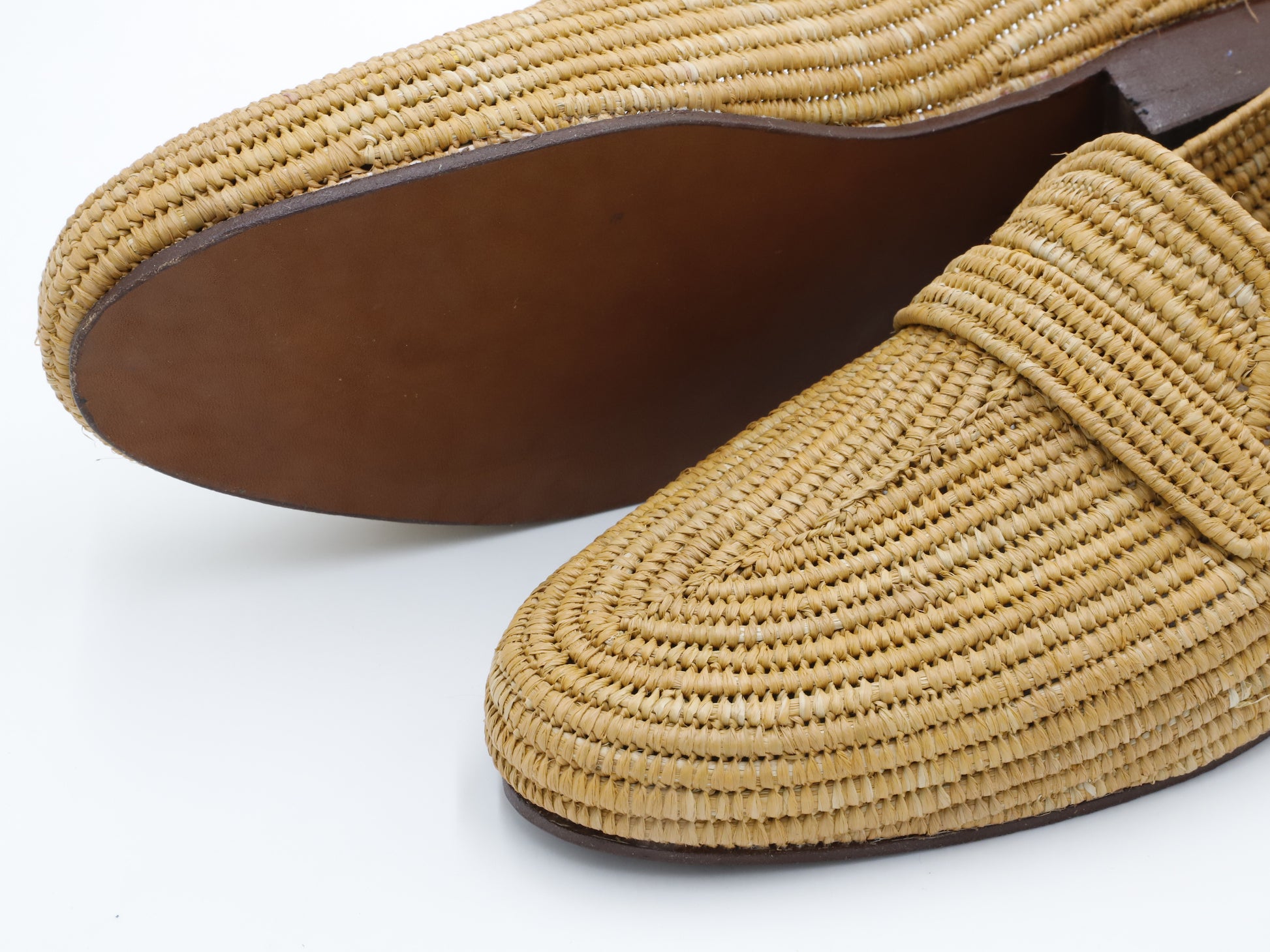 Close-up of a woven loafer shoe on a white background