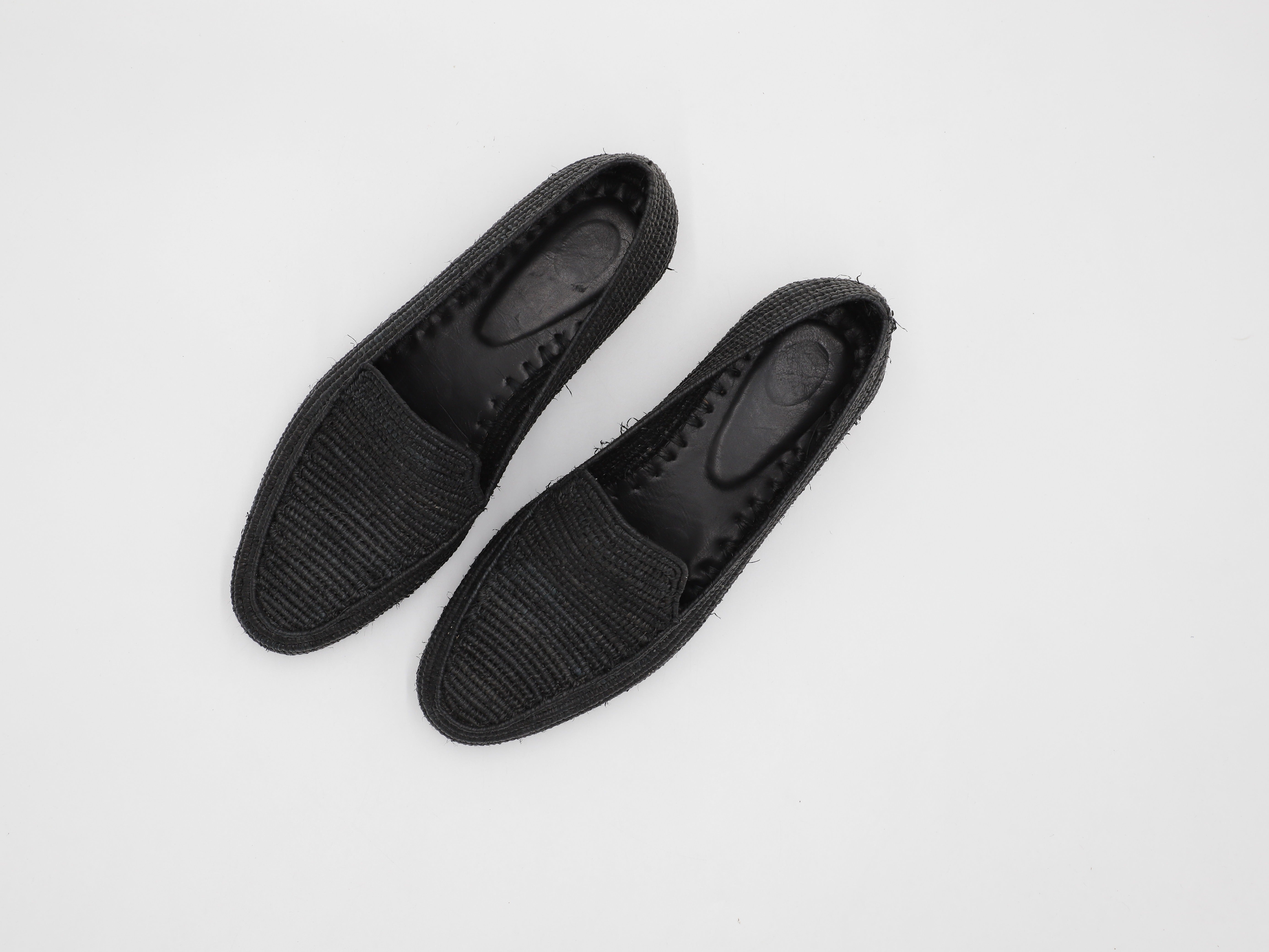 Man walking on beach wearing breathable summer raffia shoes with ocean in background